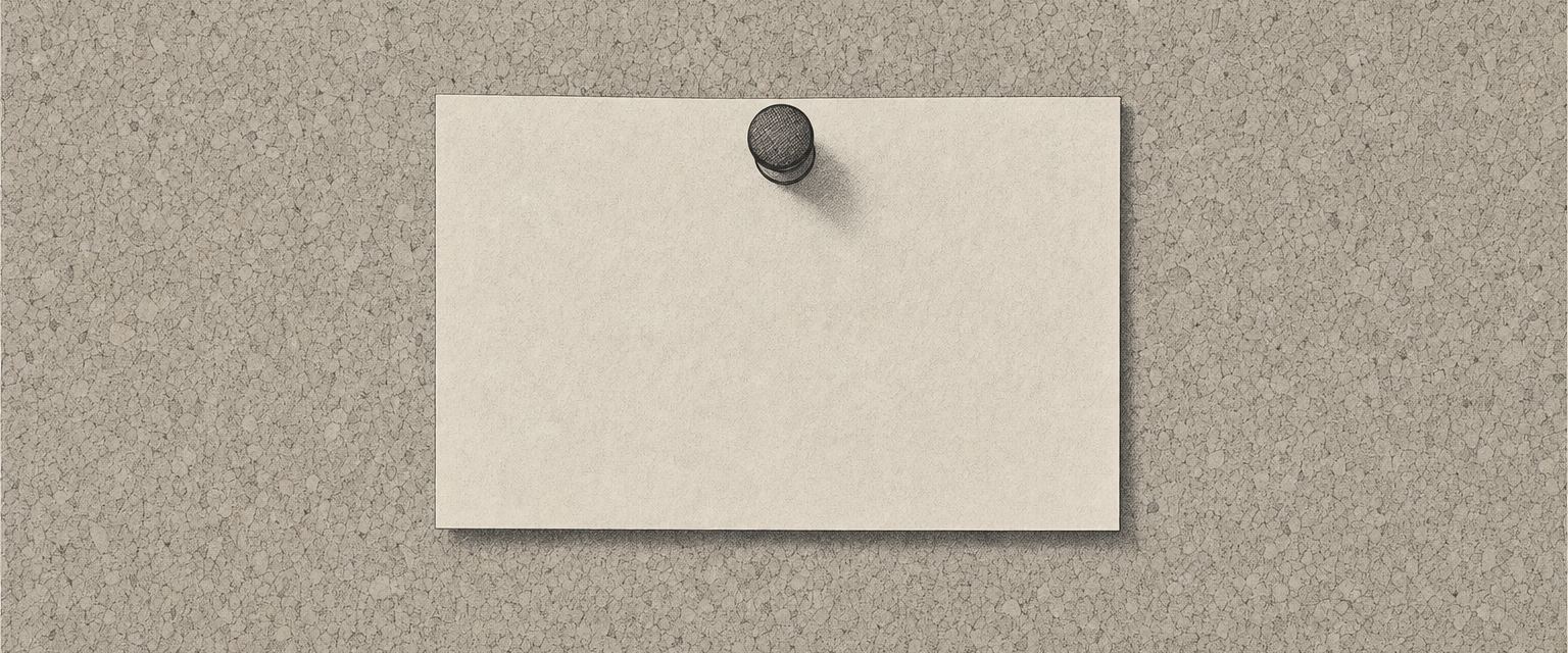 Ein einzelner leerer Papierstreifen, mit einer Nadel an eine Pinnwand gesteckt